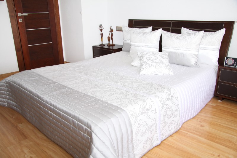 Białe narzuty eksluzywne na małe i duże łóżka z szarym ornamentem