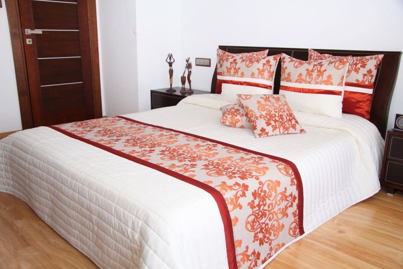 Narzuty luksusowe na łóżko koloru kremowego z pomarańczowym ornamentem