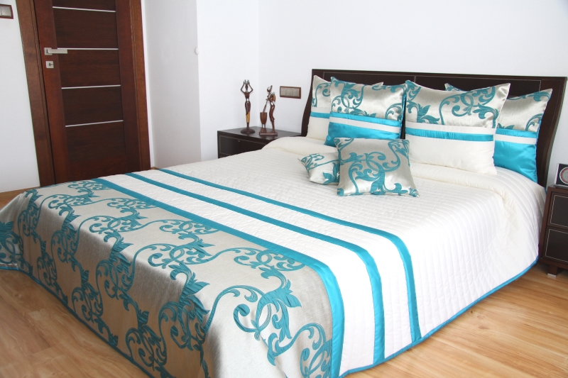 Narzuty modne na łóżko w kolorze kremowym z turkusowym ornamentem