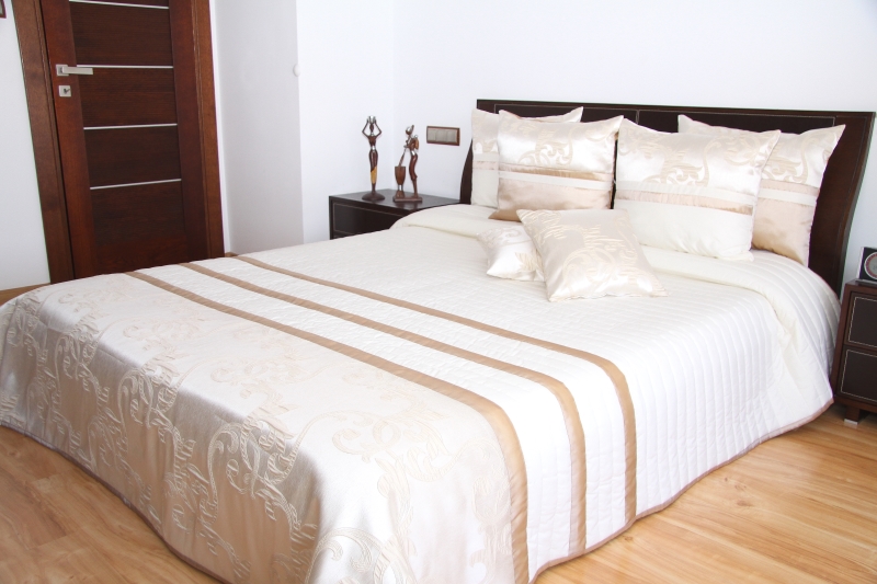 Eleganckie narzuty na małe i duże łóżka koloru kremowego z karmelowym ornamentem