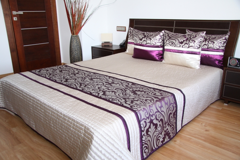 Elegancka jasnobeżowa narzuta na łóżko sypialniane z fioletowym ornamentem