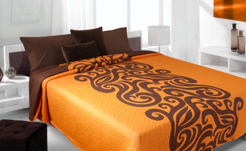Modne narzuty dwustronne na łóżko koloru pomarańczowego z brązowym wzorem